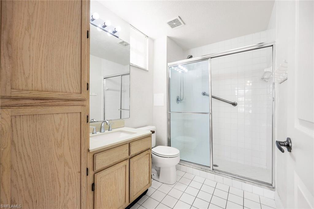 4620 St Croix Lane, Unit 911 Naples, FL 34109 - Photo 12 of 26 Bathroom featuring vanity, shower, and light tile patterned floors