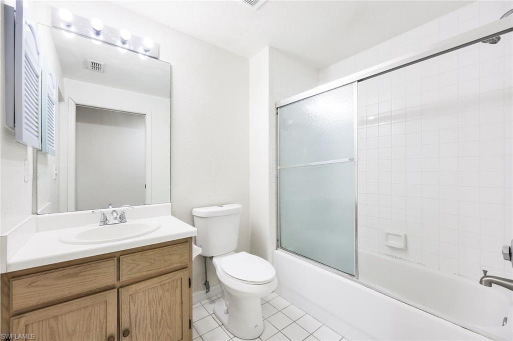 4620 St Croix Lane, Unit 911 Naples, FL 34109 - Photo 14 of 26 Bathroom with vanity, combined bath / shower with glass door, and light tile patterned flooring