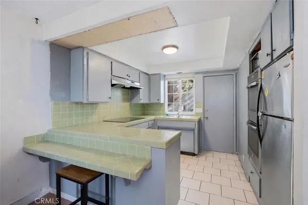 a kitchen with stainless steel appliances granite countertop a refrigerator and a stove top oven