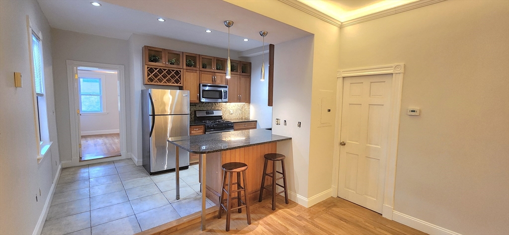 191 Maverick Street, Unit 1L Boston, MA 02128 - Photo 1 of 16 a kitchen with stainless steel appliances granite countertop a refrigerator and a stove