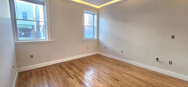 a view of a room that has wooden floor and windows