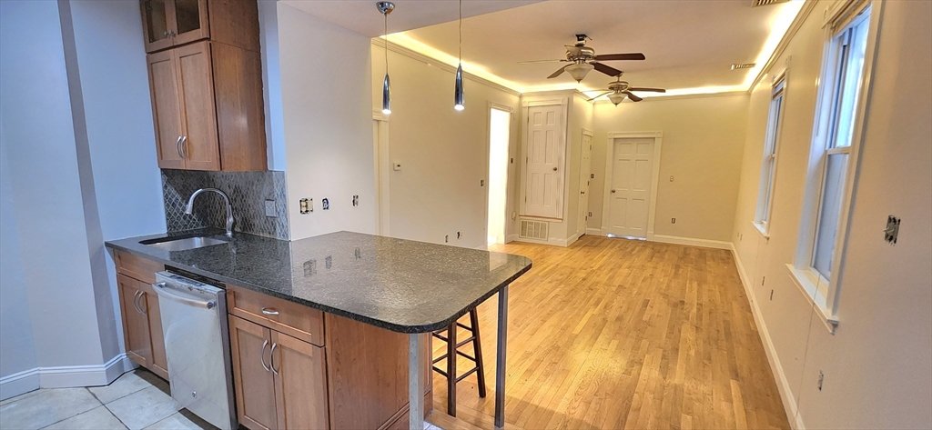 191 Maverick Street, Unit 1L Boston, MA 02128 - Photo 4 of 16 a bathroom with a granite countertop sink a mirror and shower