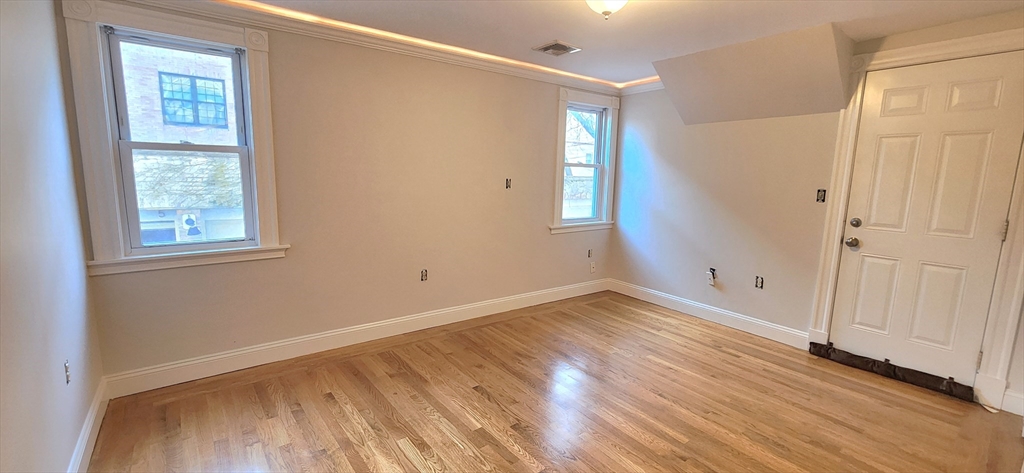 191 Maverick Street, Unit 1L Boston, MA 02128 - Photo 5 of 16 a view of empty room with wooden floor and fan