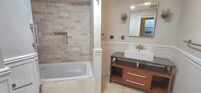 a bathroom with a sink a bathtub and a mirror