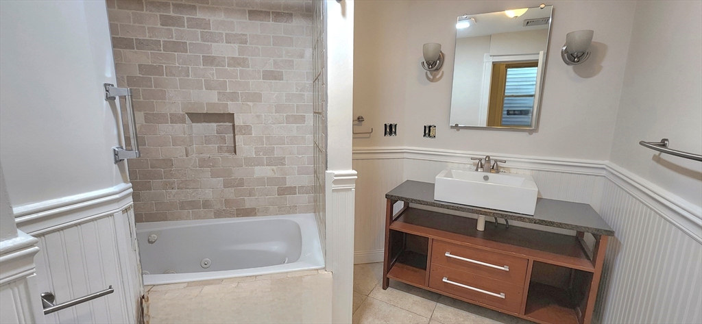 191 Maverick Street, Unit 1L Boston, MA 02128 - Photo 10 of 16 a bathroom with a sink a bathtub and a mirror