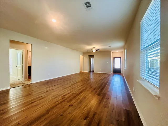 a view of empty room with wooden floor