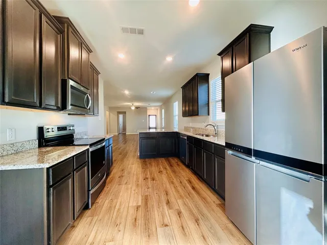 a large kitchen with stainless steel appliances and a refrigerator