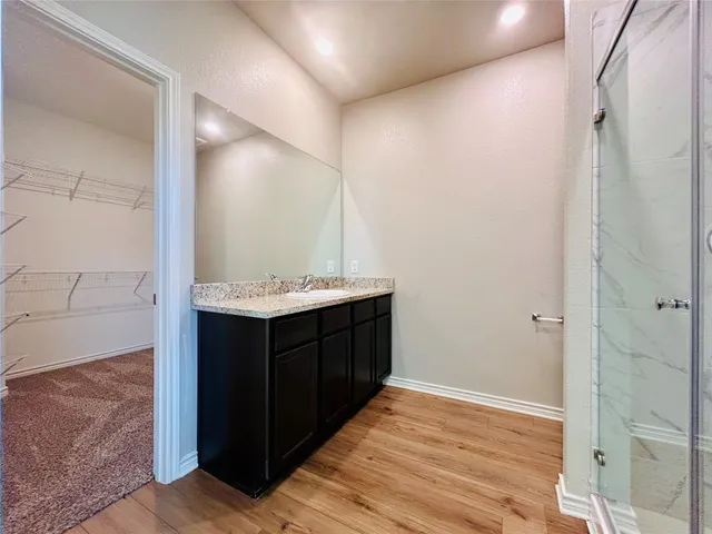 a bathroom with a vanity a sink a mirror and a shower