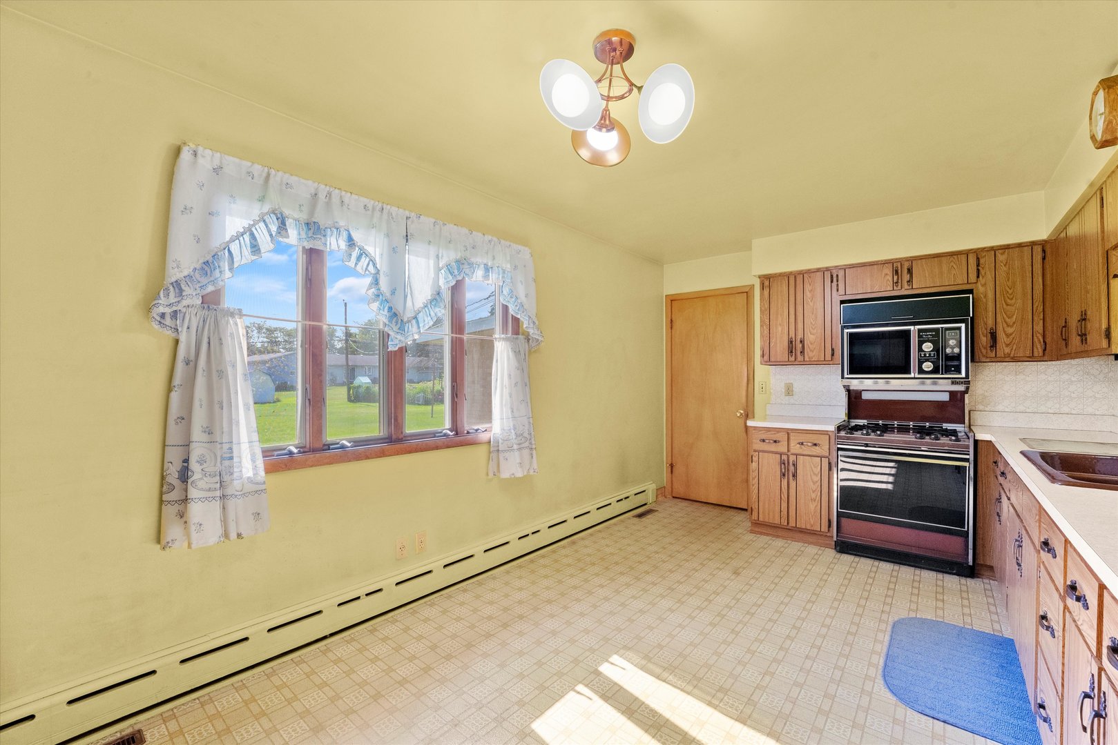 222 Roberts Road New Lenox, IL 60451 - Photo 5 of 24 a view of a kitchen with a stove wooden cabinets and a refrigerator