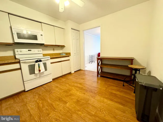 a kitchen with stainless steel appliances a stove and white cabinets