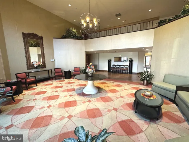 a lobby room with furniture and a chandelier