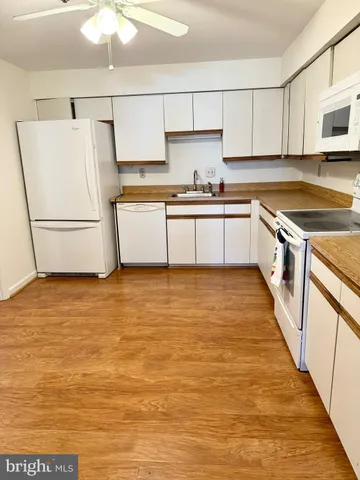 a kitchen with stainless steel appliances a refrigerator sink and white cabinets