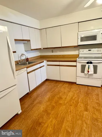 a kitchen with granite countertop a stove and white cabinets