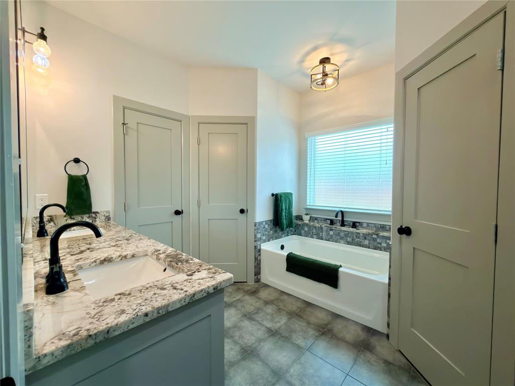 2232 Samuel Street Mabank, TX 75147 - Photo 14 of 36 a bathroom with a granite countertop sink and a mirror
