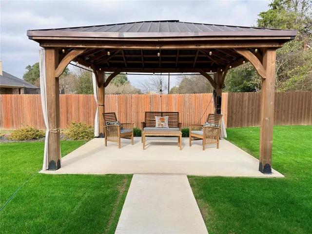 a view of a patio with a table chairs and a yard