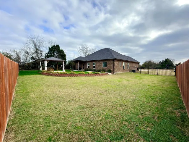 a view of a house with yard and sitting area