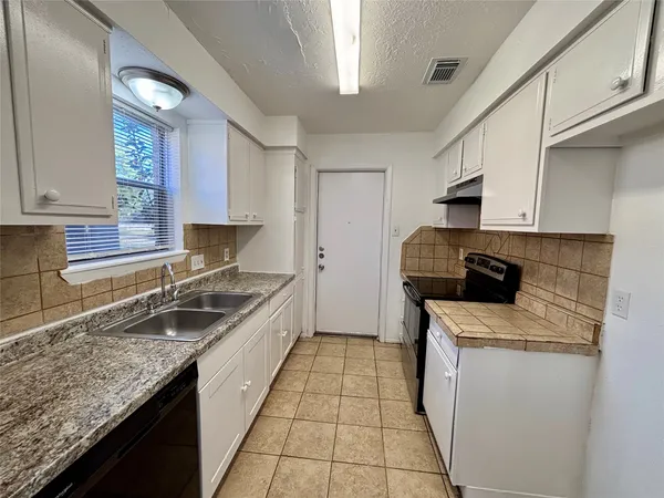 a kitchen with a sink stove and cabinets