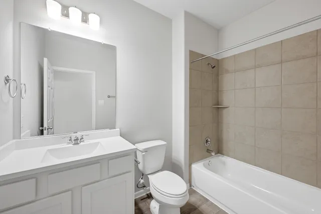 a bathroom with a toilet a sink a mirror a bathtub and shower