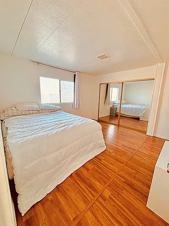 a bedroom with a bed and wooden floor