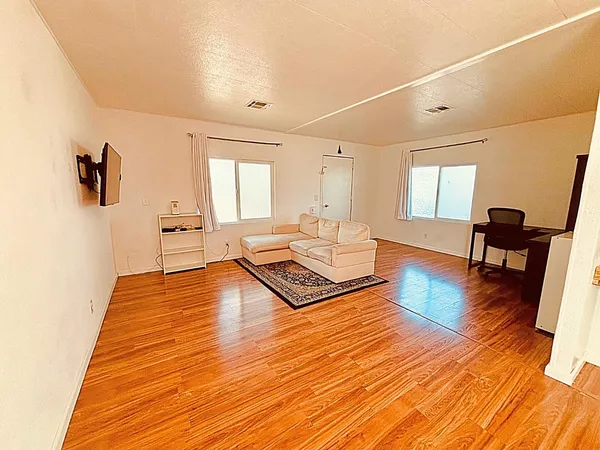 a living room with furniture and a wooden floor