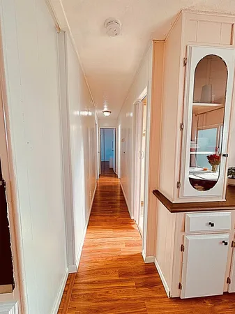 a view of a hallway with wooden floor and entryway