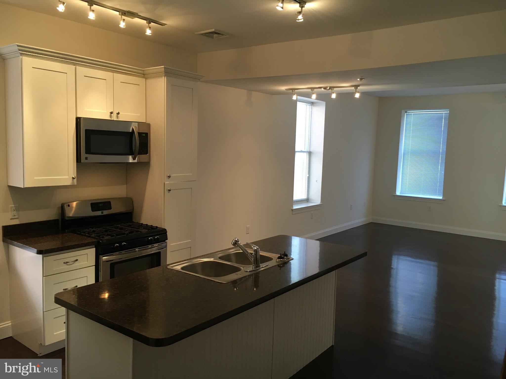 22 North George Street, Unit 1 York, PA 17401 - Photo 4 of 12 a kitchen with granite countertop a stove and a sink