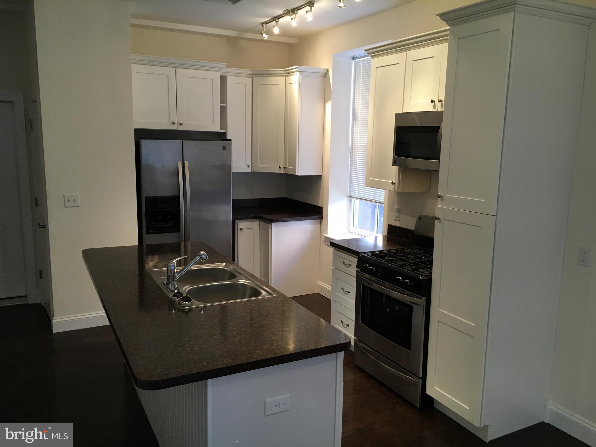 22 North George Street, Unit 1 York, PA 17401 - Photo 5 of 12 a kitchen with a sink and a refrigerator