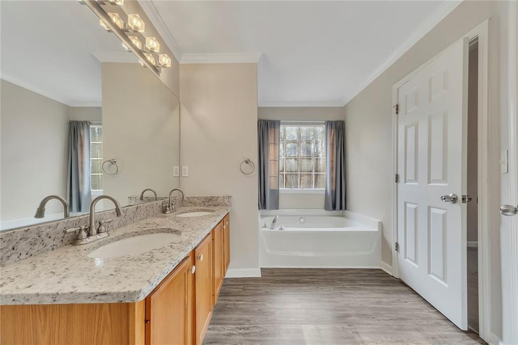 6326 Autumn View Way Northwest Acworth, GA 30101 - Photo 19 of 37 a bathroom with a granite countertop sink a mirror and a bathtub
