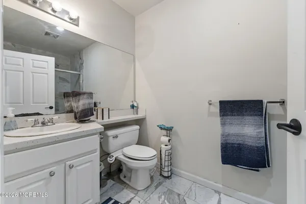 a bathroom with a toilet sink a mirror and vanity