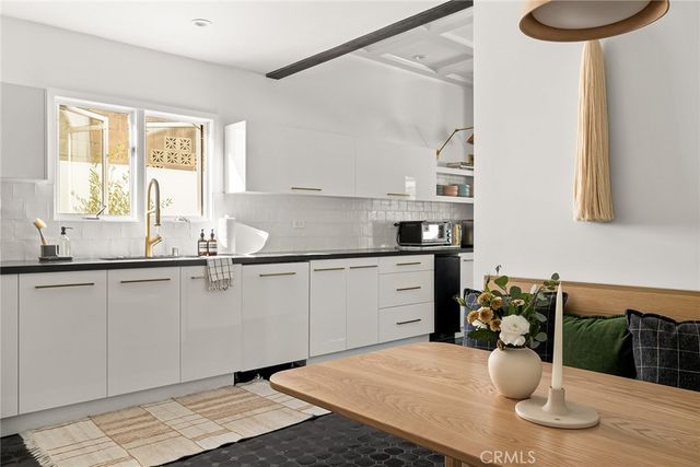 a kitchen with a stove a faucet and a dining table