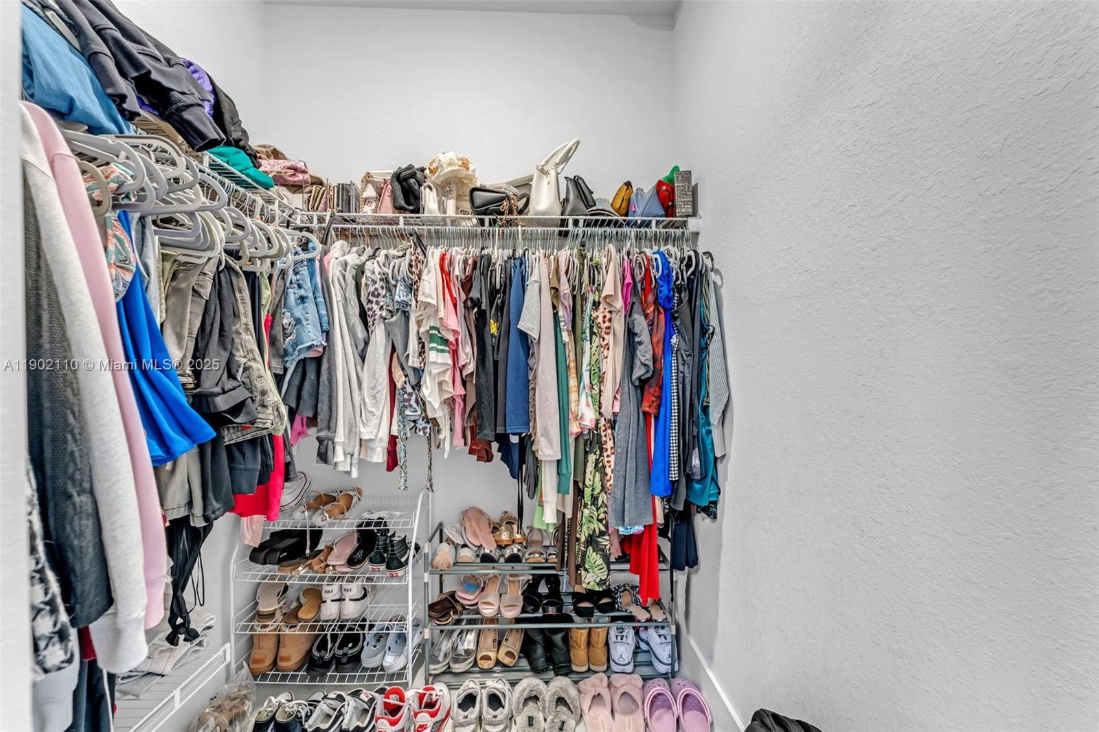 19866 Southwest 320th Street Homestead, FL 33030 - Photo 22 of 55 a view of walk in closet with clothes