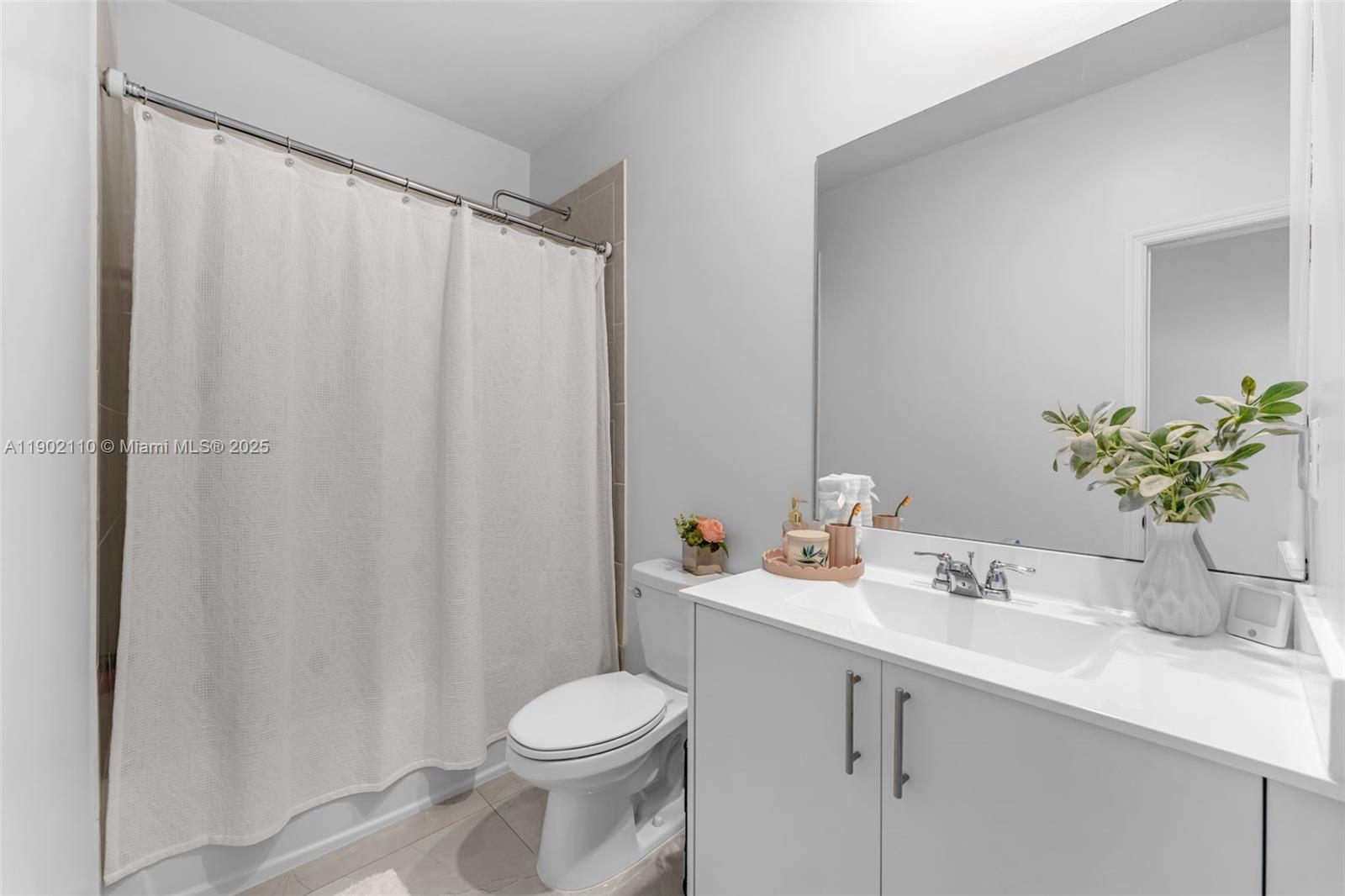 19866 Southwest 320th Street Homestead, FL 33030 - Photo 31 of 55 a bathroom with a sink a toilet and shower curtain