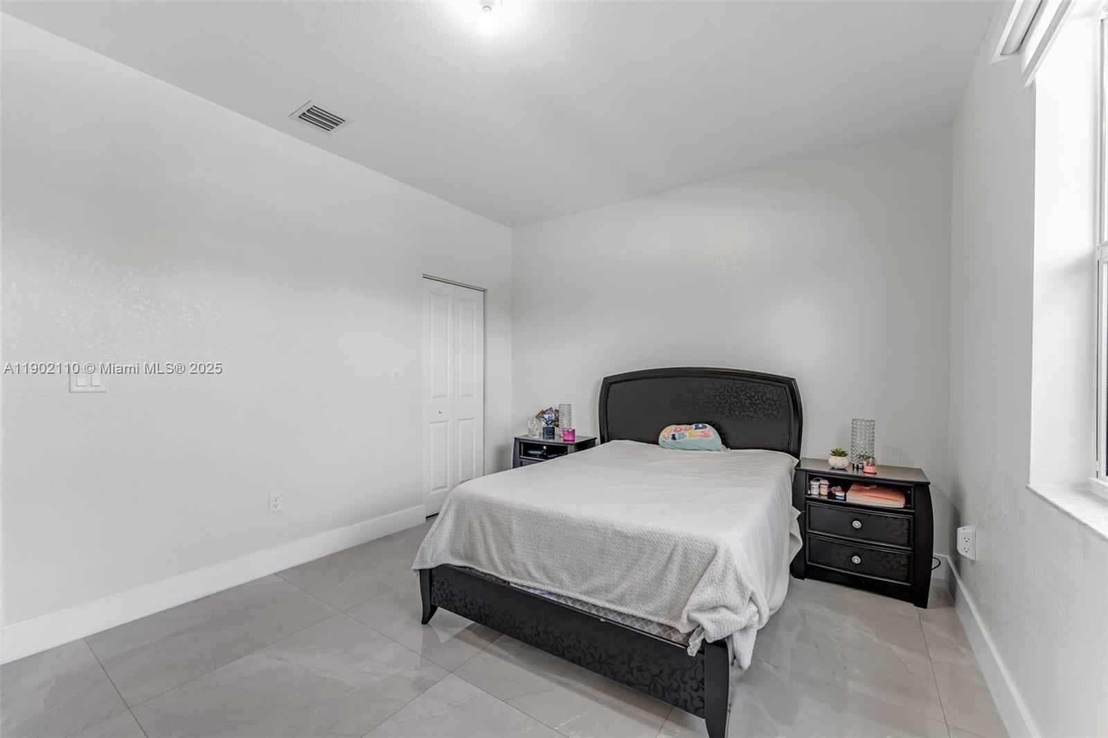 19866 Southwest 320th Street Homestead, FL 33030 - Photo 35 of 55 a bedroom with a bed and a lamp