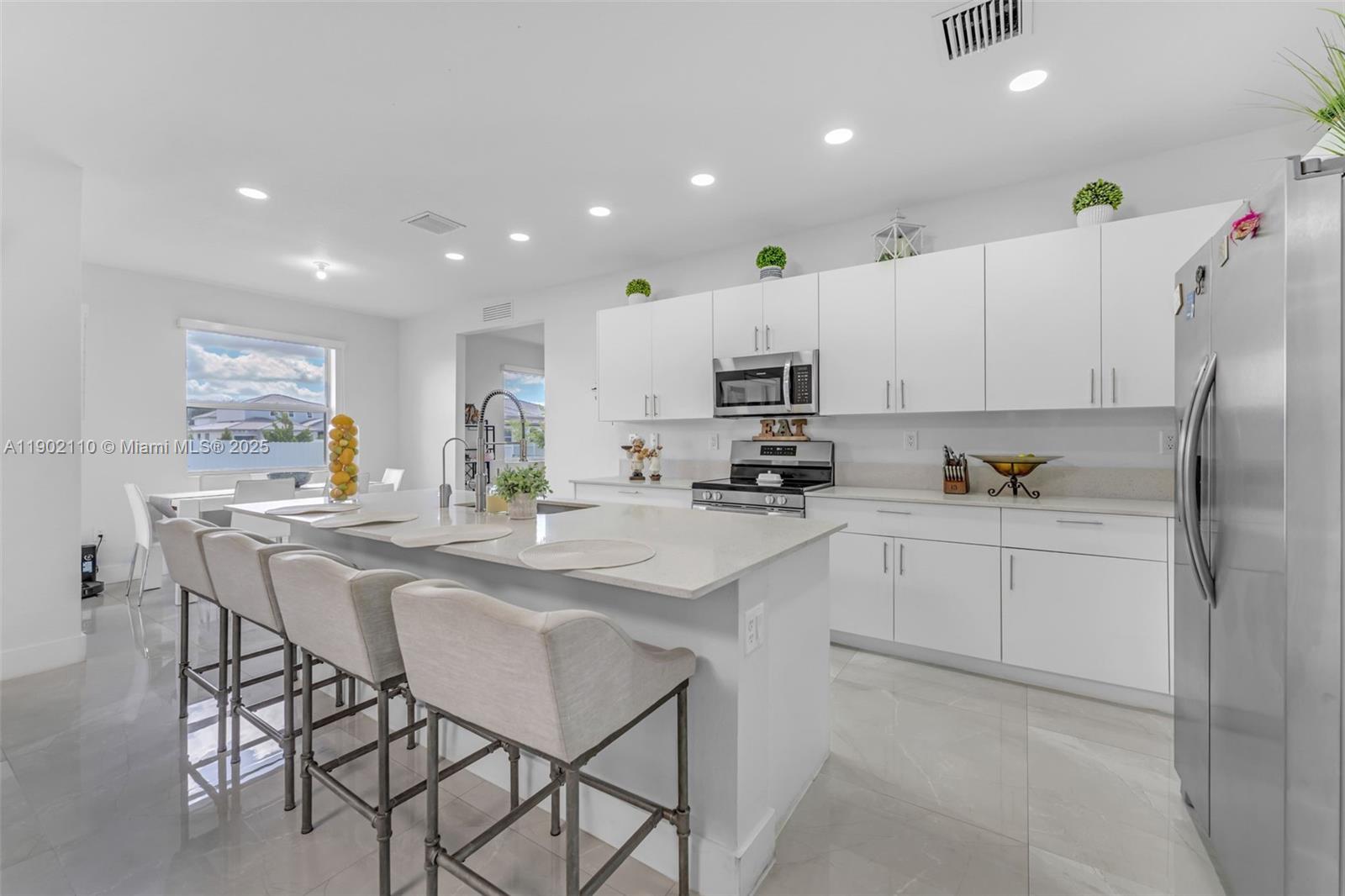 19866 Southwest 320th Street Homestead, FL 33030 - Photo 10 of 55 a kitchen with stainless steel appliances kitchen island granite countertop a sink and cabinets