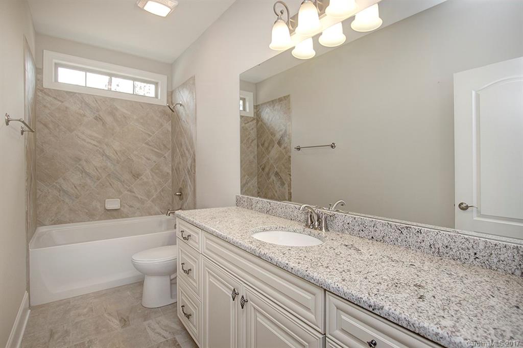 4933 River Oaks Road, Unit 113 Clover, SC 29710 - Photo 22 of 24 a bathroom with a granite countertop sink a toilet and bathtub