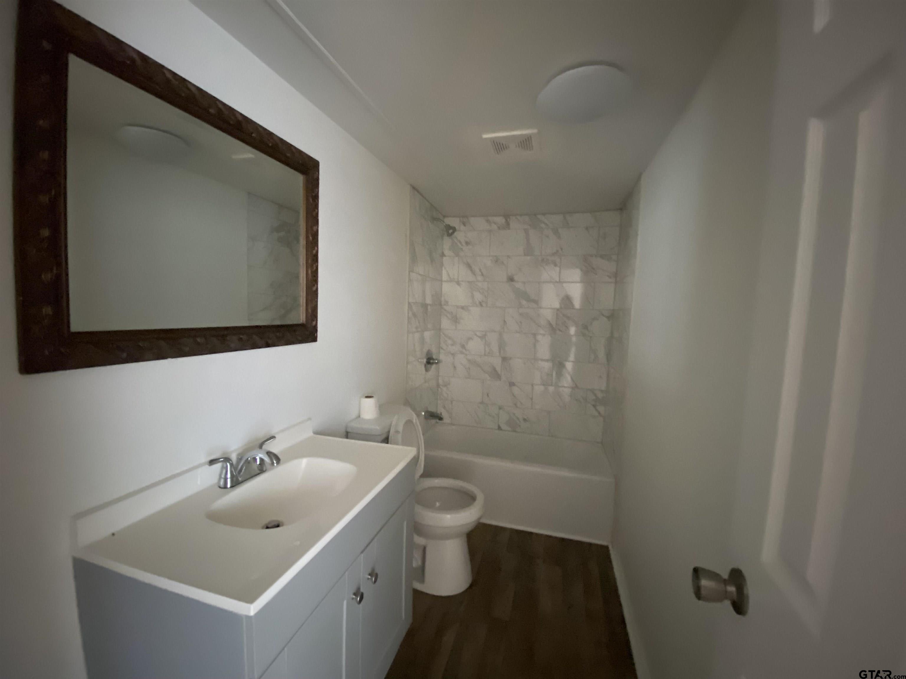 7761 Fm 1251 Henderson, TX 75652 - Photo 25 of 29 a bathroom with a sink and mirror with toilet