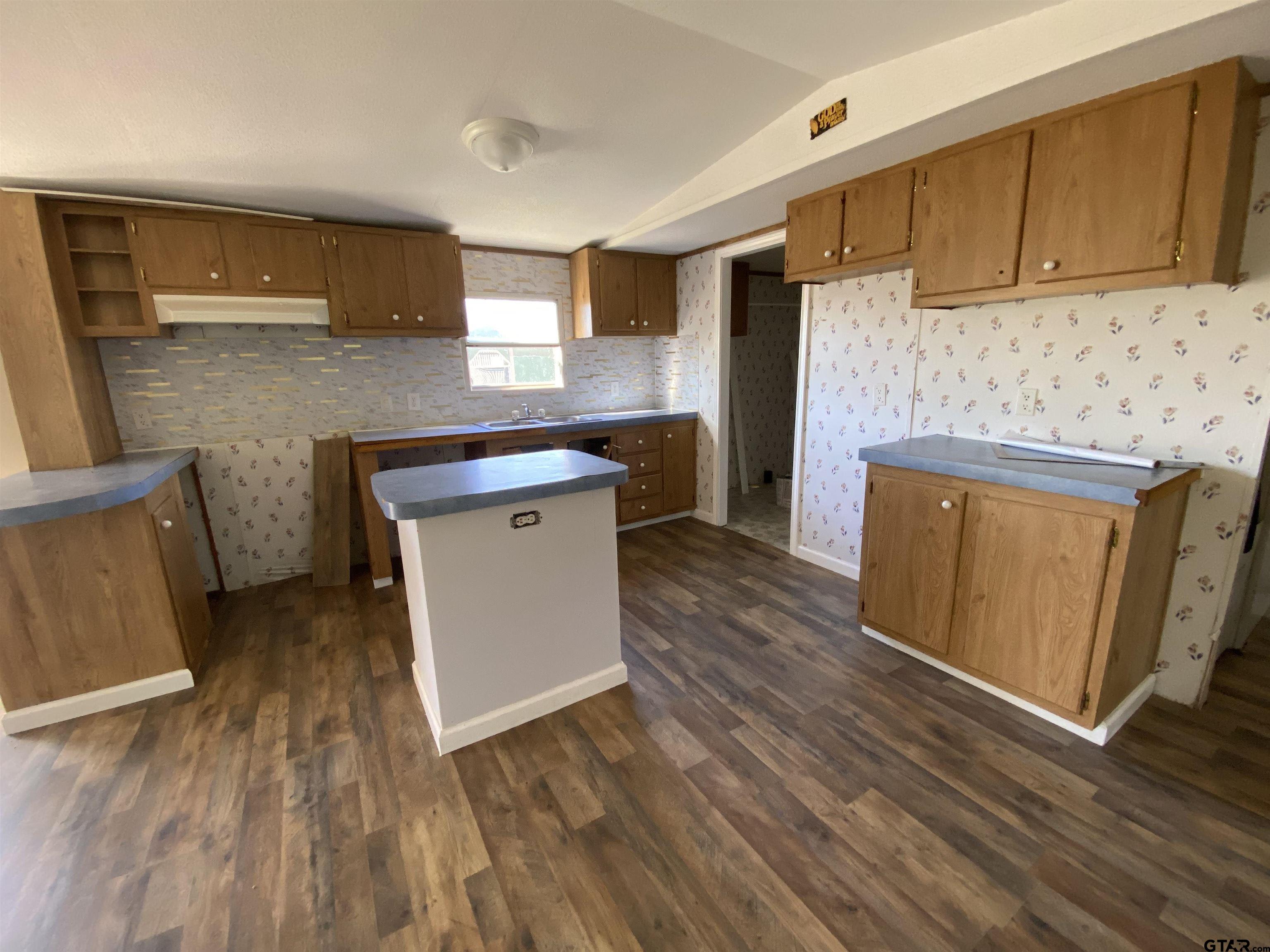7761 Fm 1251 Henderson, TX 75652 - Photo 7 of 29 a kitchen with stainless steel appliances wooden floors and wooden cabinets
