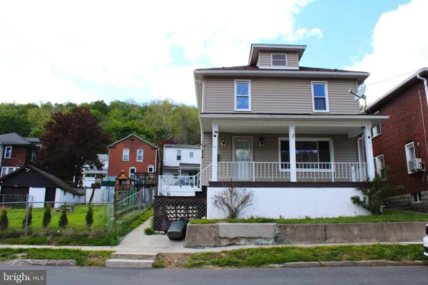 a front view of a house with a yard and potted plants