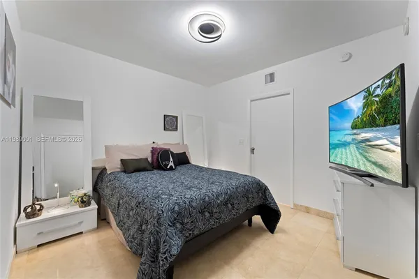 a bedroom with a bed and a flat screen tv