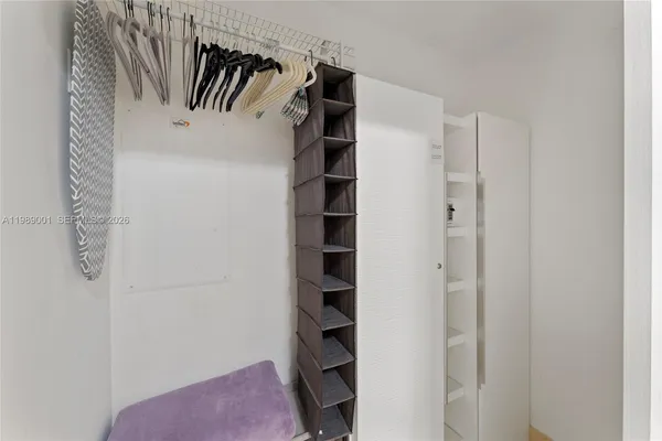a view of walk in closet with clothes and shoes