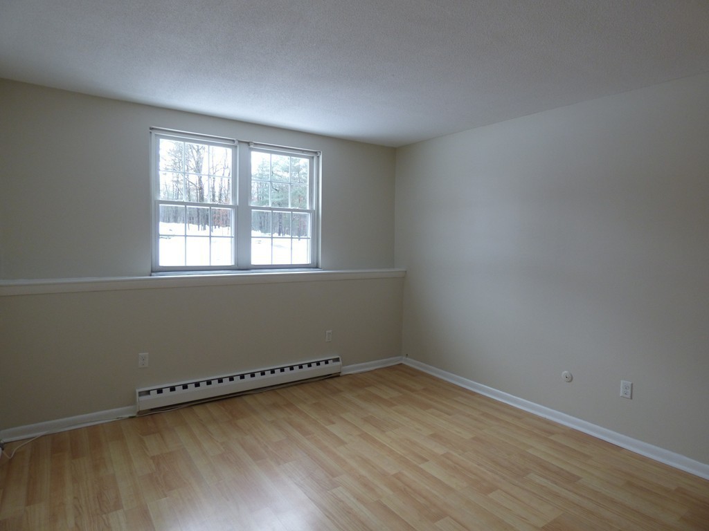 2 Leonard Road, Unit 2 Boxborough, MA 01719 - Photo 11 of 17 an empty room with wooden floor and windows