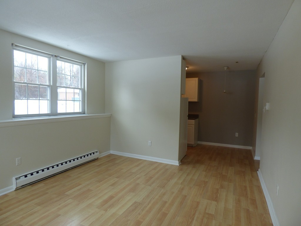 2 Leonard Road, Unit 2 Boxborough, MA 01719 - Photo 7 of 17 an empty room with wooden floor and windows