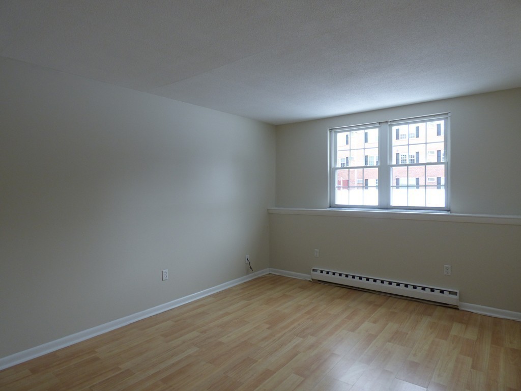 2 Leonard Road, Unit 2 Boxborough, MA 01719 - Photo 10 of 17 an empty room with wooden floor and windows