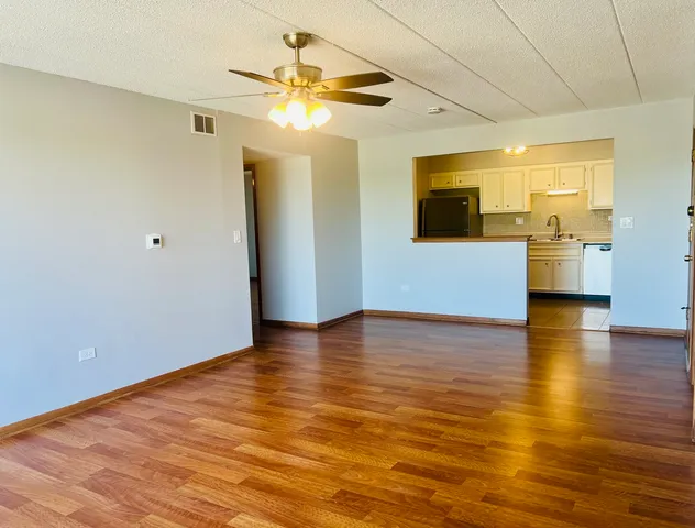 a view of empty room with wooden floor