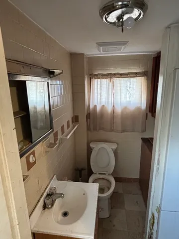 a bathroom with a toilet sink and mirror
