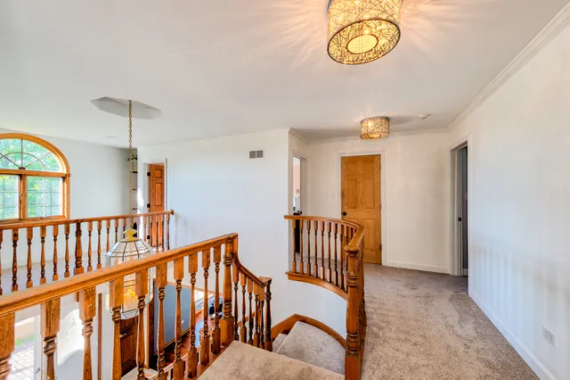 a view of a hallway with wooden floor and windows