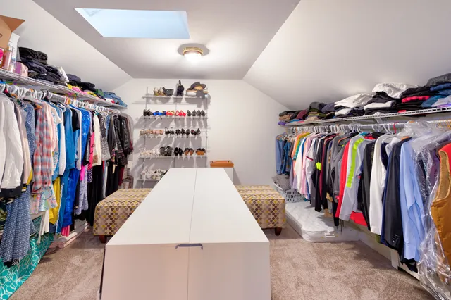 a view of walk in closet with clothes and shoes