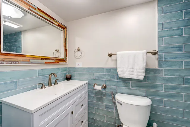 a bathroom with a toilet sink and mirror