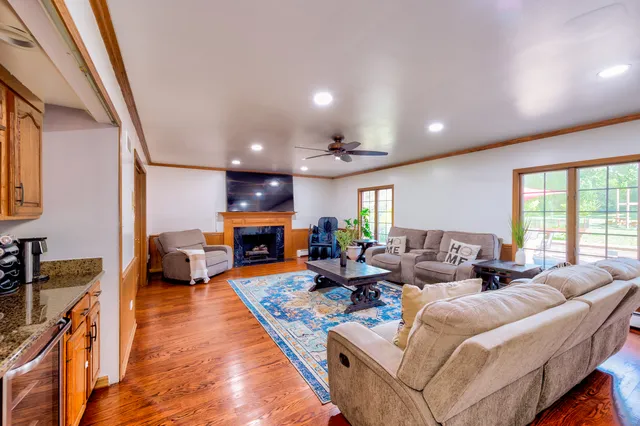 a living room with fireplace furniture and a large window