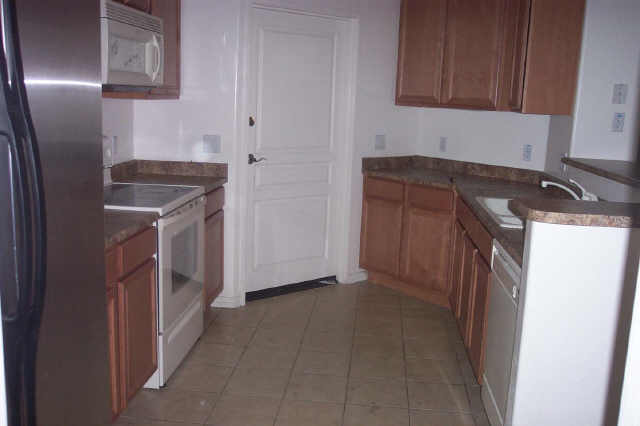 4488 East Thomas Road, Unit 1034 Phoenix, AZ 85018 - Photo 3 of 6 a kitchen with a refrigerator sink and cabinets